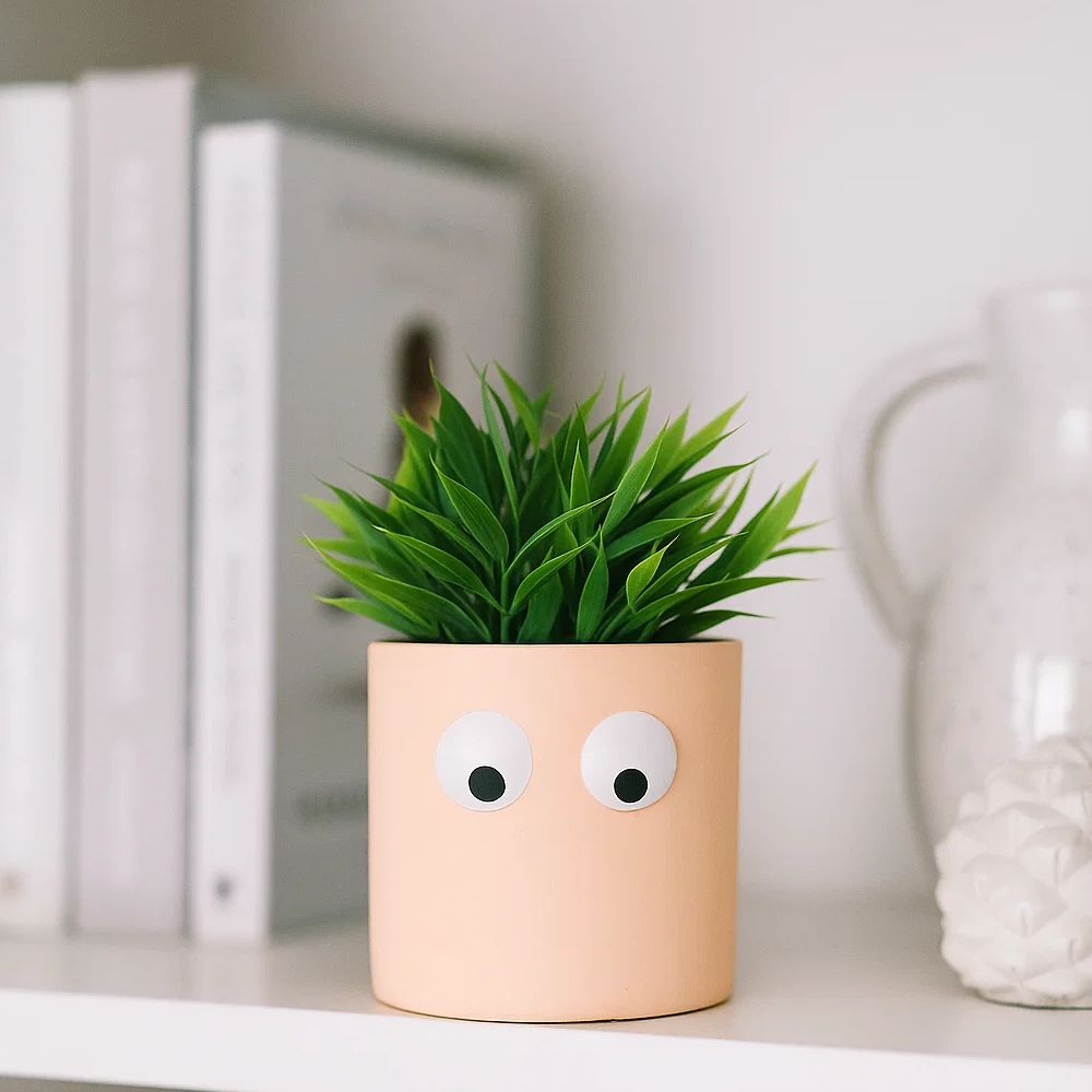 Face of Green Ceramic Planter With Playful Eye Design